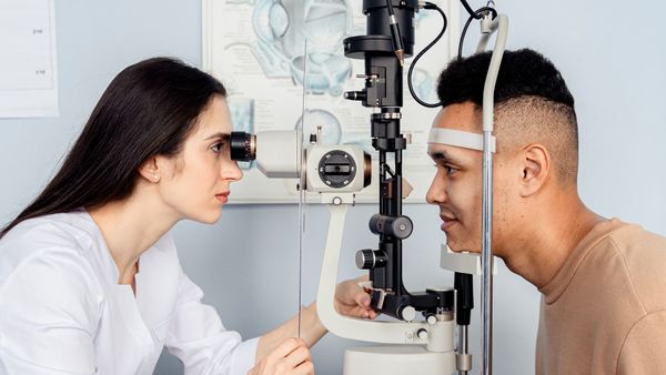 A patient having their eyes examined at Visions Optique.