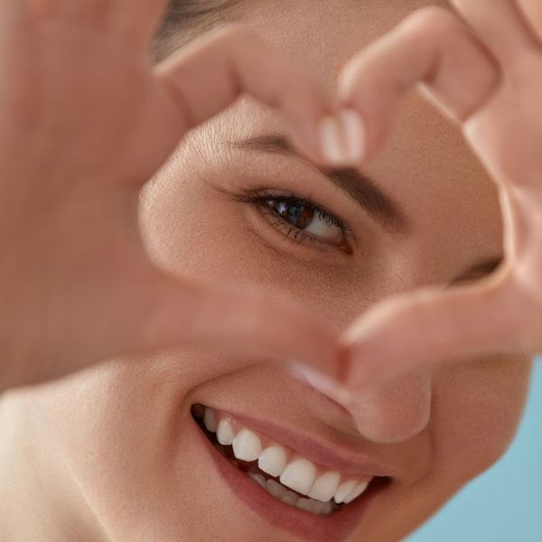 woman making a heart with her fingers and putting it over her eye