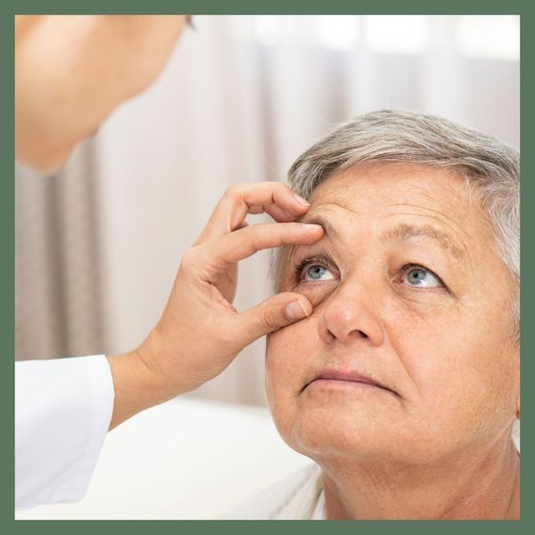 optometrist opening patient's eye