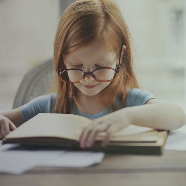 young girl in glasses reading