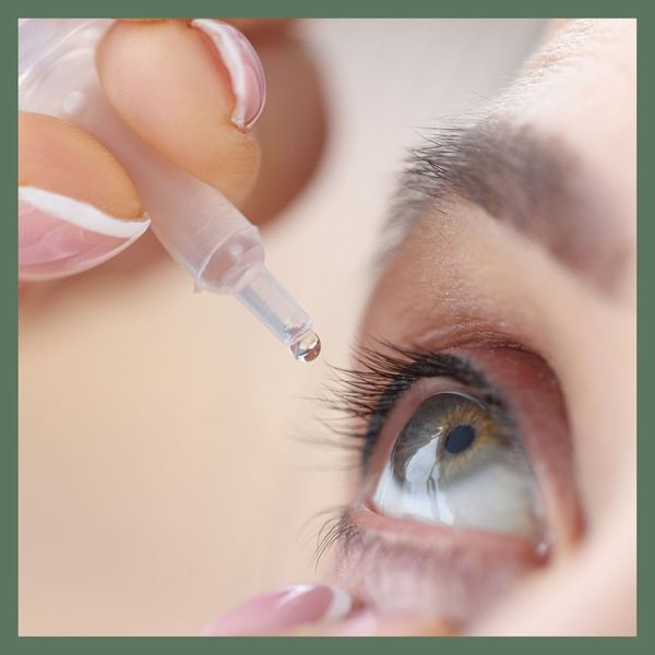 person administering eye drops