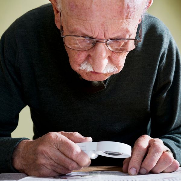man using a magnifying glass to read