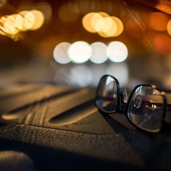 glasses on car dashboard at night