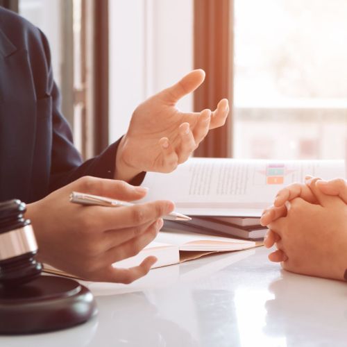 Lawyer talking with a person at a table with a gavel in front