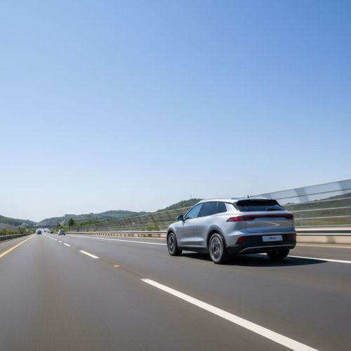 A car travels down a modern multi-lane highway during a bright, clear day.