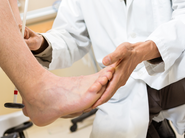 A doctor inspecting a patient with foot pain.
