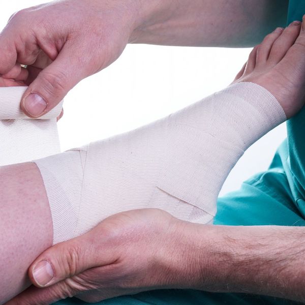 doctor wrapping ankle