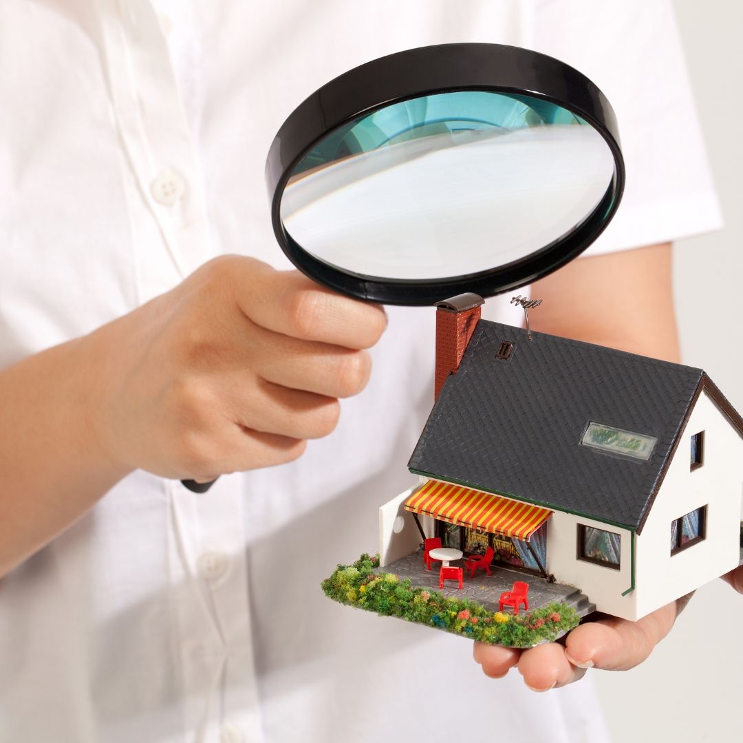 Magnifying glass over a toy home