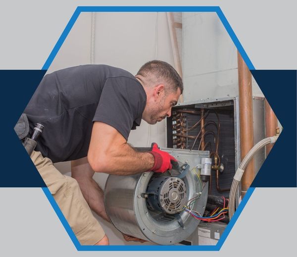 Close-up on a technician's hands skillfully servicing a modern gas furnace, illustrating comprehensive heating system services.