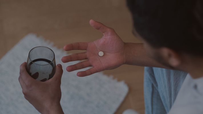 man holding medication in hand