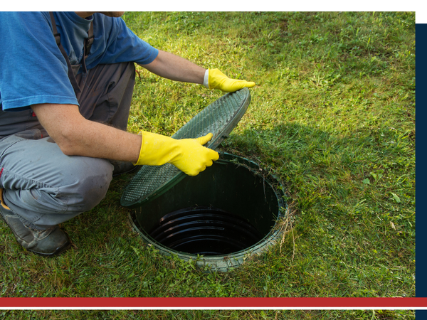 Man lifting the cover to an underground septic tank