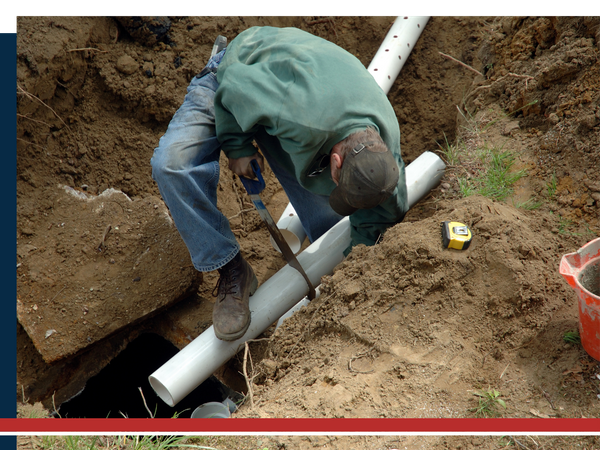Man cutting a pipe for an underground septic tank Man cutting a pipe for an underground septic tank