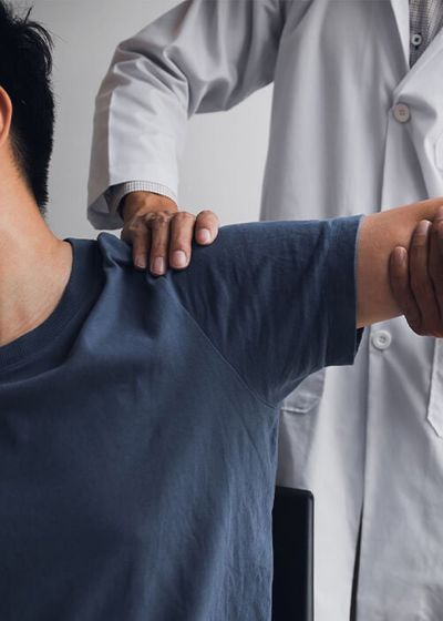 person getting shoulder adjusted by chiropractor