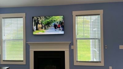 blue living room walls with tv mounted above mantel