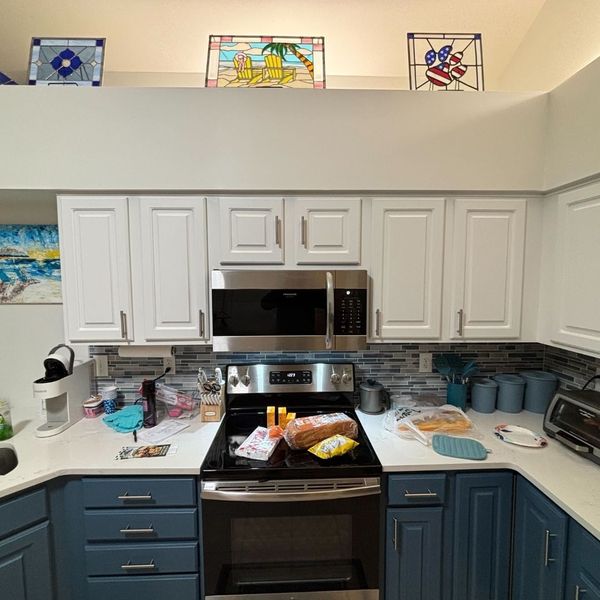kitchen with blue and white cabinets and white walls