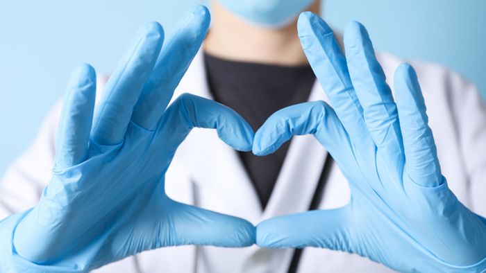Doctor making a heart with their fingers. 