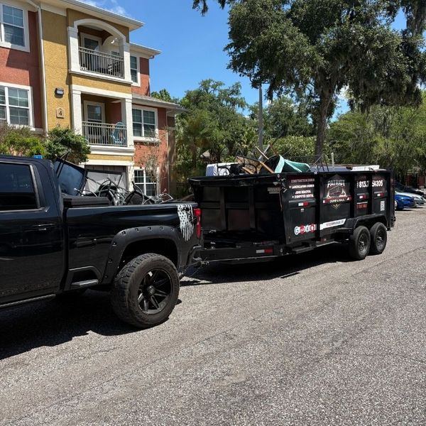 A truck with a Patriot Dump and Haul dumpster attatched