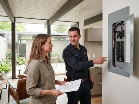 Electrician explaining electrical panel to a homeowner