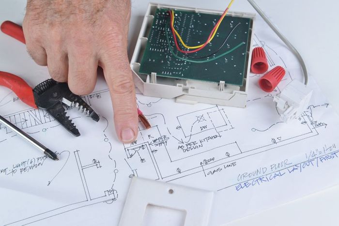 electrician pointing at a blueprint