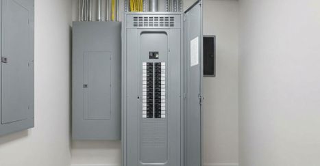 an organized, light gray electrical panel installed neatly in a utility closet with natural light