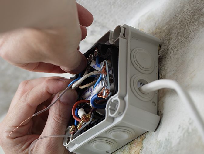 An electrician wiring a light switch