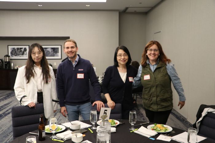 Smiling guests seated at event dinner table