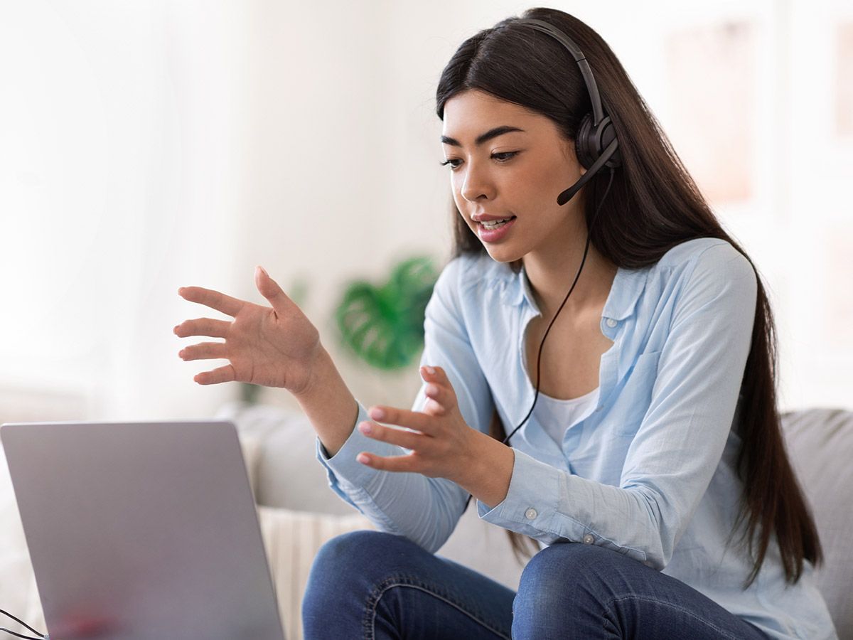 Young asian female talking during an online video call at home.