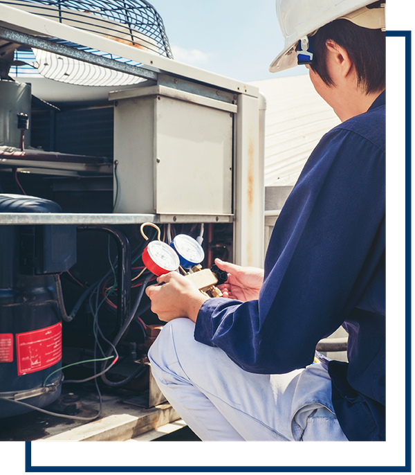 worker checking commercial ac unit