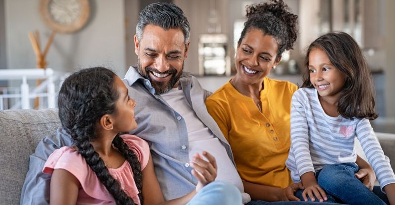 A family smiling together on a couch