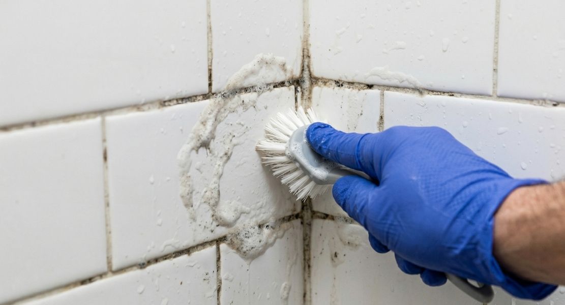 Scrubbing soap scum from a shower corner