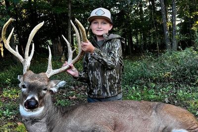A young girl next to a deer.