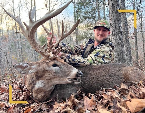 man proudly displaying antlers of dead dder