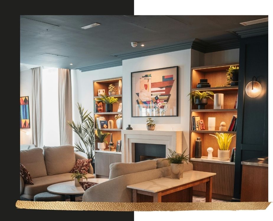 Sophisticated living room renovation with a matte charcoal grey ceiling and matching crown molding, custom lighted built-in shelving, and a modern white fireplace.