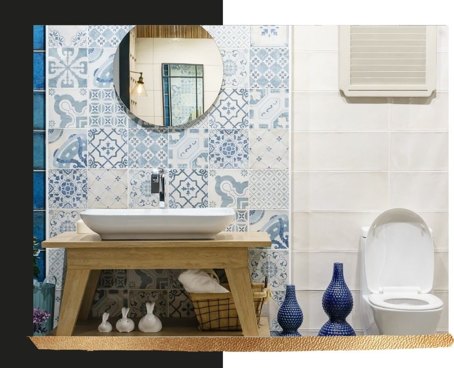 bathroom featuring a blue and white patterned tile accent wall, a light wood vanity, and a white vessel sink.