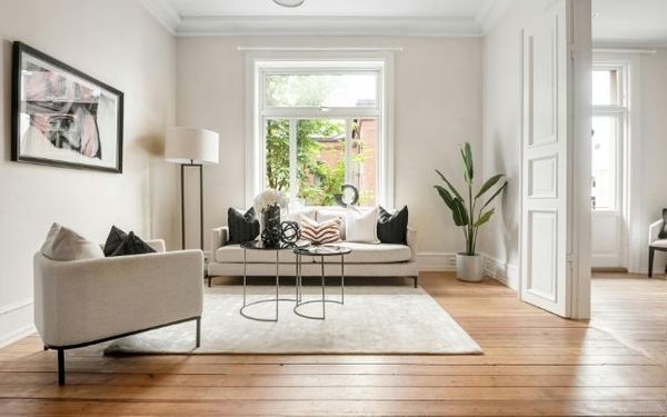 Bright living room showcasing professionally installed wide-plank natural oak hardwood flooring.