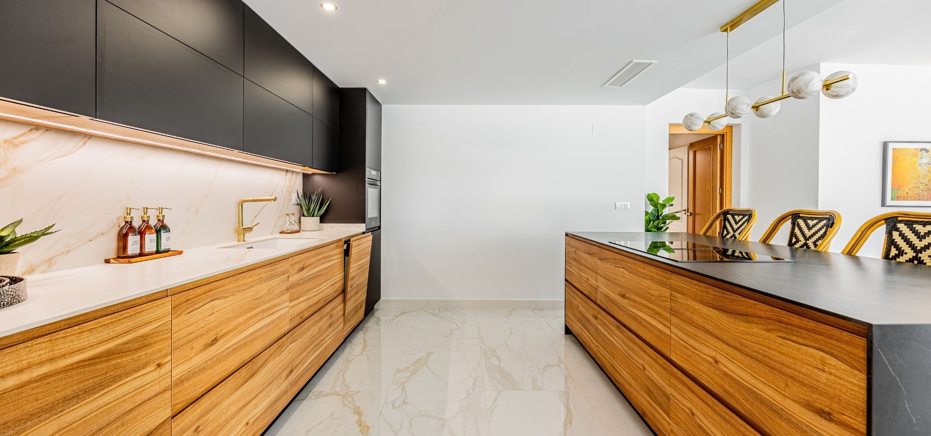 Ultra-modern kitchen showcasing wood-grain lower cabinets, matte black upper cabinets, a dark countertop island, and white marble backsplash.