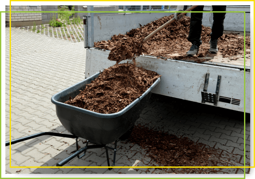 hardwood mulch being loaded into a wheelbarrow hardwood mulch being loaded into a wheelbarrow
