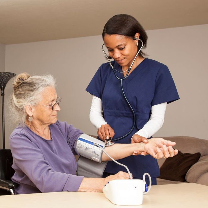 Older woman getting blood pressure taken by nurse