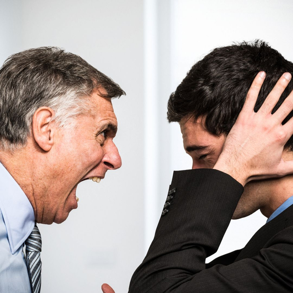 Man screaming at another man who is covering his ears