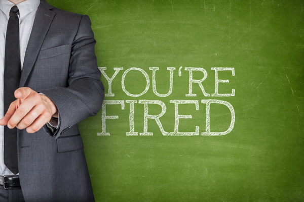 ‘You’re Fired’ written on a blackboard with a businessman pointing his finger. 