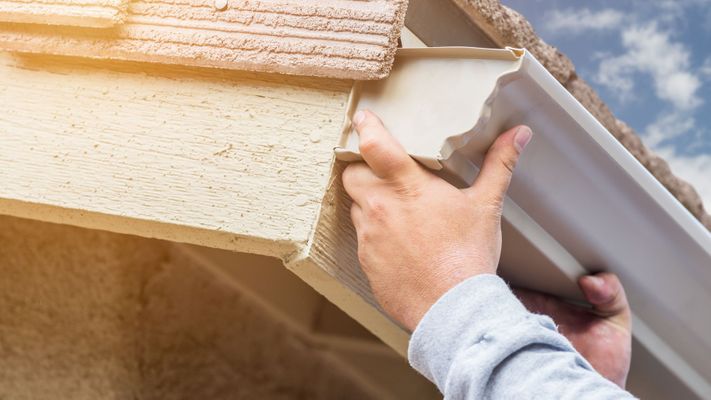 Man installs gutters on home