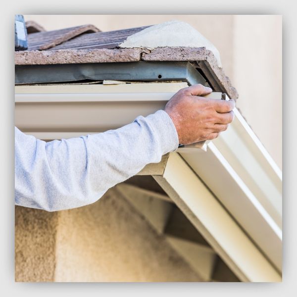 Man leveling his house gutters