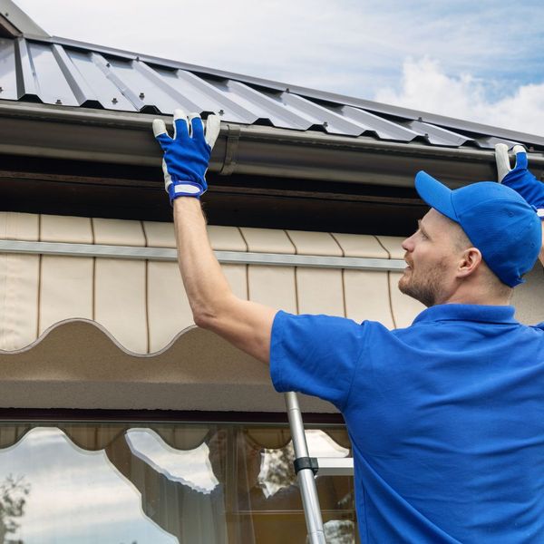 professional inspecting gutter