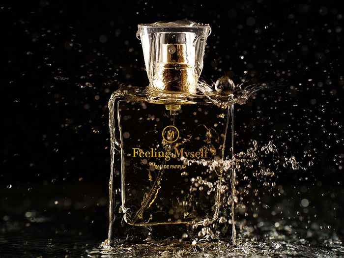 A perfume bottle with water splashing around it
