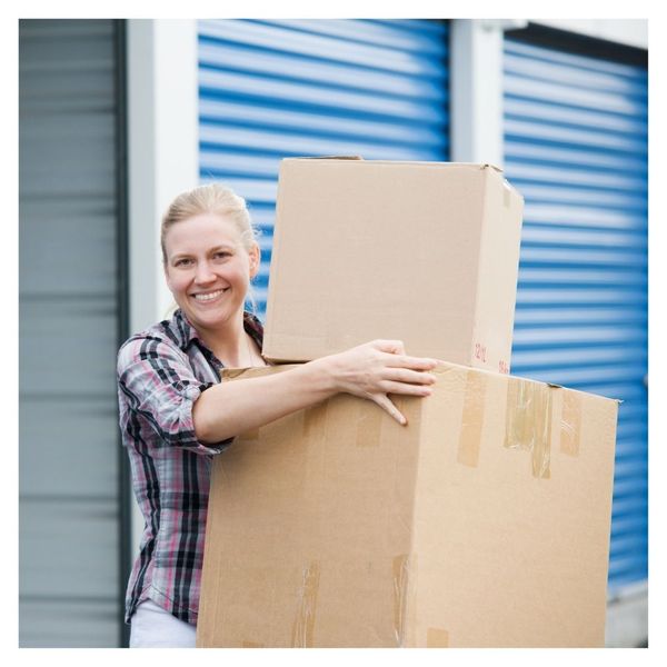 smiling woman holding boxes at storage center