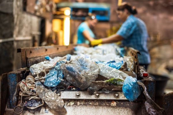 people sorting waste at garbage facility