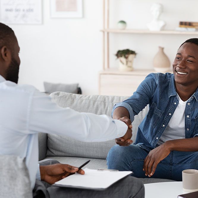 Young man and therapist shaking hands