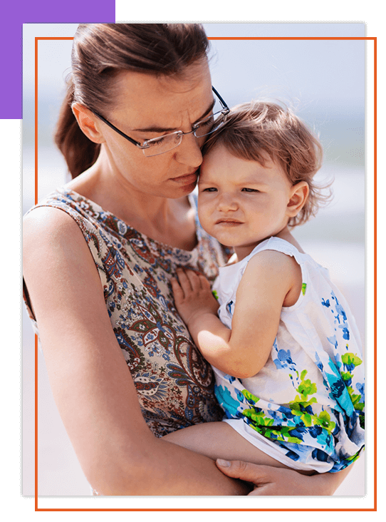 Woman who seems slightly depressed holding a child