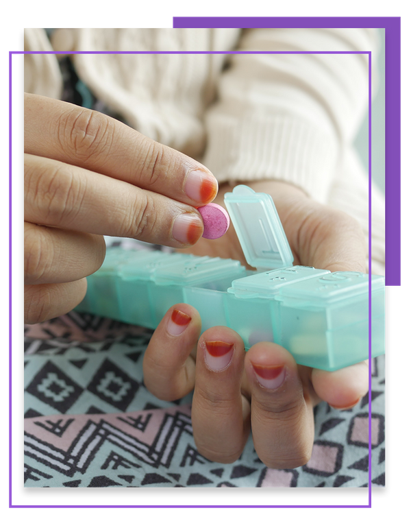 Person taking a pill out of medication box