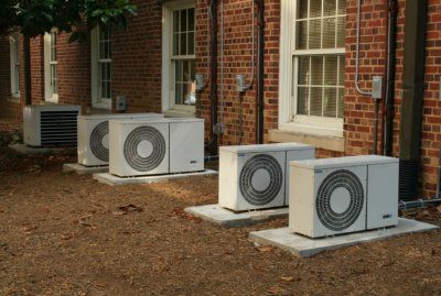 Five air conditioning units outside of red brick building.jpg